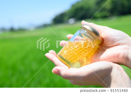 Bottled honey in my hand 91551480