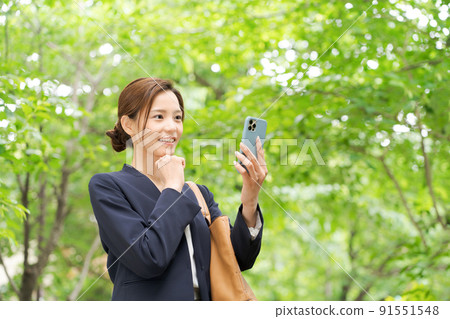 一個有智能手機的女人，新鮮的綠色 91551548