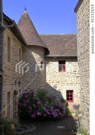 A stone house with a triangular roof and hydrangea ... (France) 91552654