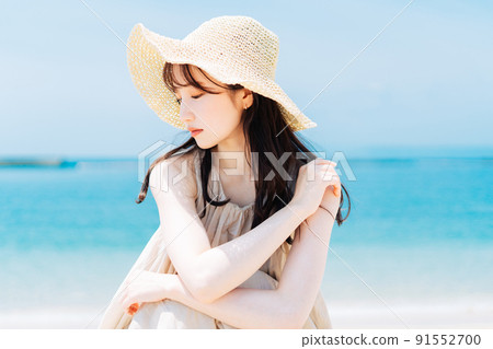 Woman against the backdrop of the sea and blue sky Woman against the backdrop of the sea and blue sky 91552700