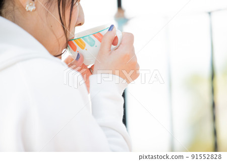 A woman relaxing at tea time A woman relaxing at tea time 91552828