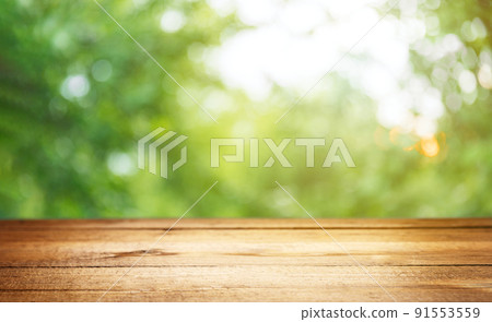 Empty rustic wooden texture of old wood table top, blur against green park with defocused sunlight, blurred foliage backyard background. Display mock up, montage your product, design key visual layout 91553559