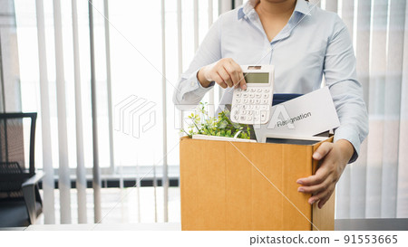 Concept of leaving job, Female employee packing personal belonging and resignation letter in box 91553665