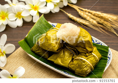 Thai dessert concept, Khao tom mat made from bananas with sticky rice in plate on wooden table Thai dessert concept, Khao tom mat made from bananas with sticky rice in plate on wooden table 91553701