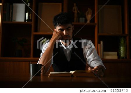 Thoughtful asian businessman focused reading some paragraph on the book 91553743