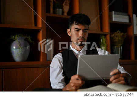 Professional asian male boss or CEO focused reading some information on the paper 91553744