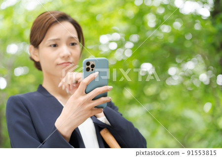 一個有智能手機的女人，新鮮的綠色 91553815
