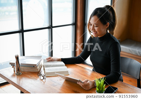 Beautiful young asian female college student doing homework, reading a book 91553960