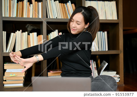 Female worker or freelancer stretching her arms, relaxes her arms Female worker or freelancer stretching her arms, relaxes her arms 91553977