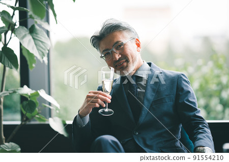 Senior owner with a glass of champagne 91554210