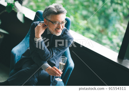 Senior owner drinking champagne in the lounge Senior owner drinking champagne in the lounge 91554311