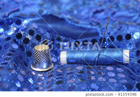 Blue Thread with needle and thimble on blue prom dress Blue Thread with needle and thimble on blue prom dress 91554396