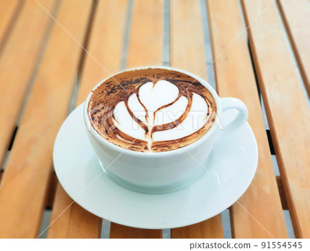 High angle Latte art coffee on wooden table in coffee shop. High angle Latte art coffee on wooden table in coffee shop. 91554545