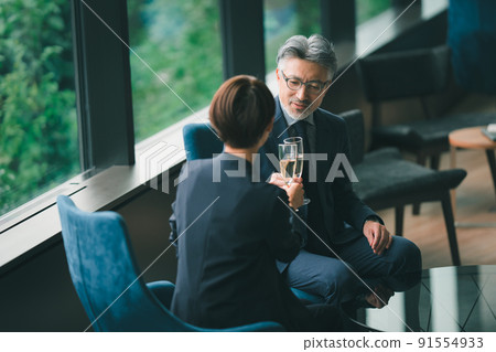 Senior manager and secretary drinking champagne in the lounge 91554933