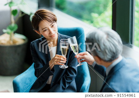 Senior manager and secretary drinking champagne in the lounge 91554961