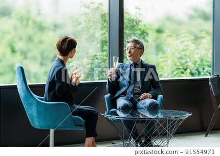 高級經理和秘書在休息室喝香檳 91554971