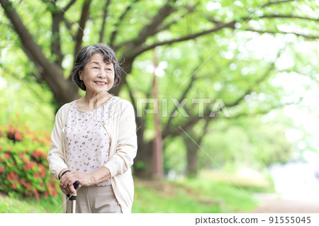 Senior woman taking a walk in the park Senior woman taking a walk in the park 91555045