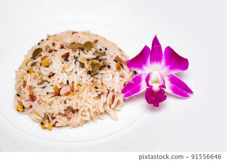 isolated brown rice with the purple orchid beside for decoration on white background. isolated brown rice with the purple orchid beside for decoration on white background. 91556646
