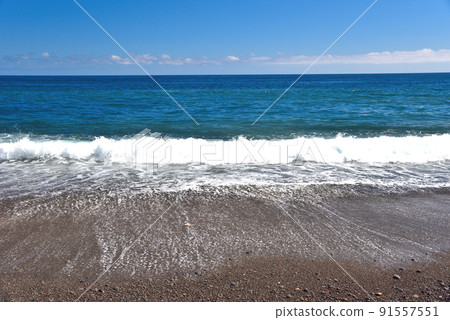 White waves crashing against the coast on a clear day White waves crashing against the coast on a clear day 91557551