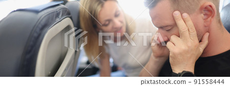 A man calms himself down in the aircraft cabin, aerophobia A man calms himself down in the aircraft cabin, aerophobia 91558444