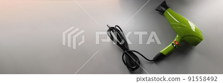 Green hair dryer on a gray background, top view Green hair dryer on a gray background, top view 91558492