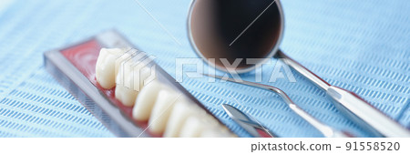 Orthodontist tools and dental bridge on a blue background 91558520