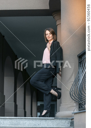 Full-length portrait of young female director in business casual clothing. Girl in pantsuit. Full-length portrait of young female director in business casual clothing. Girl in pantsuit. 91560456