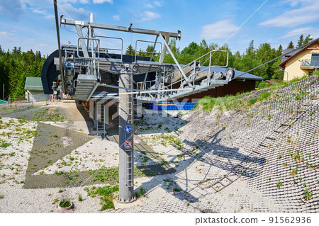 Open cable car line. Metal cable and moving rollers on platform for funicular mechanism, close up. Karpacz resort in Poland with lift road Open cable car line. Metal cable and moving rollers on platform for funicular mechanism, close up. Karpacz resort in Poland with lift road 91562936