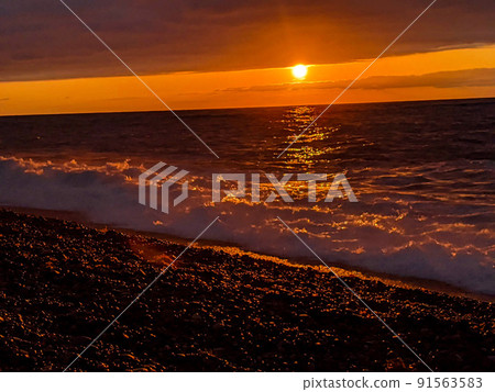 Material image of the setting sun. Sunset on the Sea of Japan in early summer. Sunset on the beach 91563583