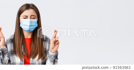 Coronavirus outbreak, leisure on quarantine, social distancing and emotions concept. Close-up of hopeful, dreamy young girl making wish, close eyes and cross fingers good luck Coronavirus outbreak, leisure on quarantine, social distancing and emotions concept. Close-up of hopeful, dreamy young girl making wish, close eyes and cross fingers good luck 91563861