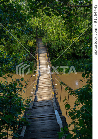 old suspension bridge over the river in the countryside going into perspective old suspension bridge over the river in the countryside going into perspective 91564445