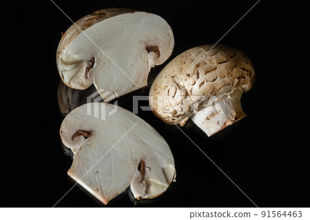 Mushrooms champignons on a black mirror surface isolated on black background 91564463