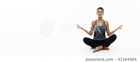 Healthy and Fitness concept - Beautiful American African lady in fitness clothing doing yoga and meditation. Isolated on white background. Healthy and Fitness concept - Beautiful American African lady in fitness clothing doing yoga and meditation. Isolated on white background. 91564804