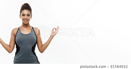 Healthy and Fitness concept - Beautiful American African lady in fitness clothing doing yoga and meditation. Isolated on white background. Healthy and Fitness concept - Beautiful American African lady in fitness clothing doing yoga and meditation. Isolated on white background. 91564832