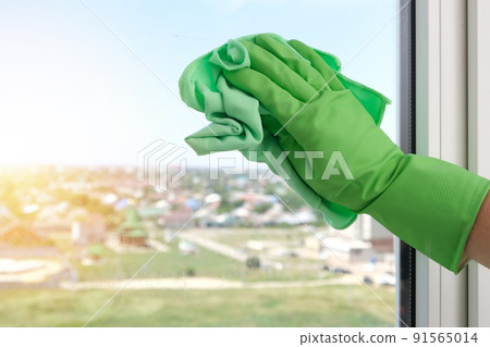 A man washes a glass window and plastic frame with A man washes a glass window and plastic frame with 91565014