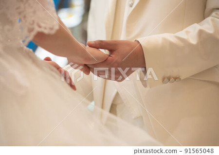 Bride and groom holding hands and swearing love 91565048