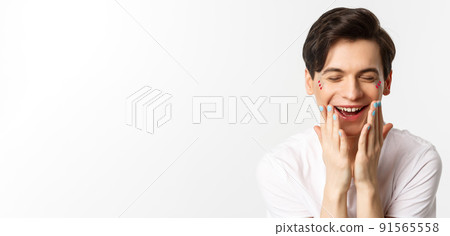 People, lgbtq and beauty concept. Close-up of beautiful gay man with polished nails, laughing and looking happy, white background People, lgbtq and beauty concept. Close-up of beautiful gay man with polished nails, laughing and looking happy, white background 91565558