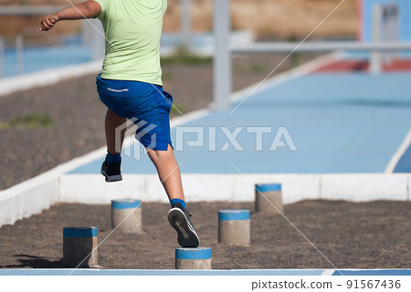 Mud race runners. The chid overcoming the obstacle Mud race runners. The chid overcoming the obstacle 91567436
