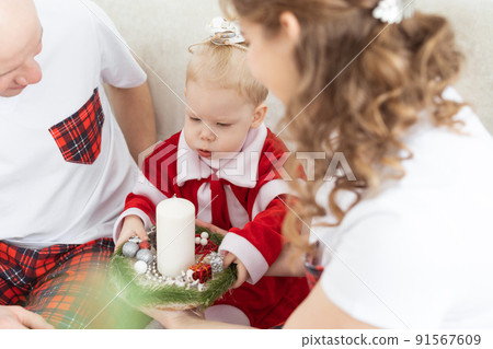 Baby child with hearing aid and cochlear implant having fun with parents in christmas room. Deaf , diversity and health concept 91567609