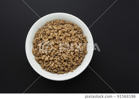 Bowl of buckwheat flakes on black background 91568196