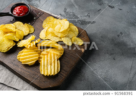 Variation different potato chips on gray stone table background, with copy space for text 91568391