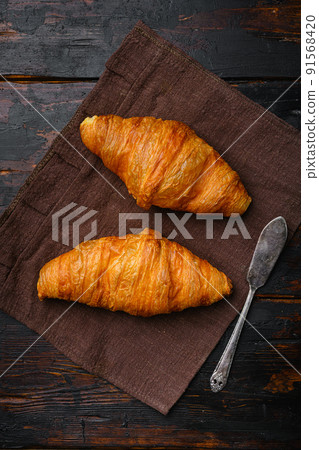 Fresh croissants on table set, on old dark  wooden table background, top view flat lay 91568420