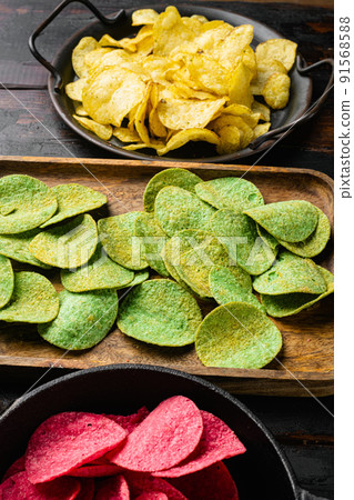 Green potato chips on old dark  wooden table background 91568588