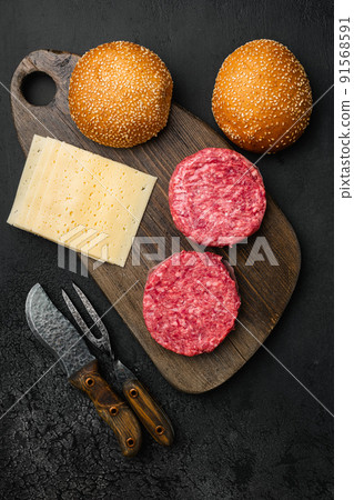 Raw Ground beef meat Burger patties on black dark stone table background, top view flat lay 91568591
