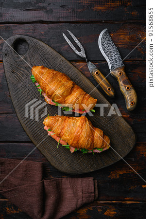 Croissant sandwich with salmon, on old dark  wooden table background, top view flat lay 91568655