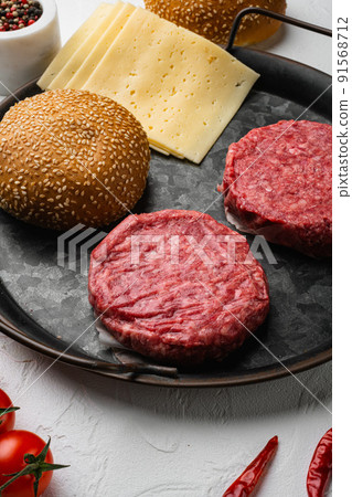 Raw BBQ Beef Burger Cutlets on white stone table background 91568712