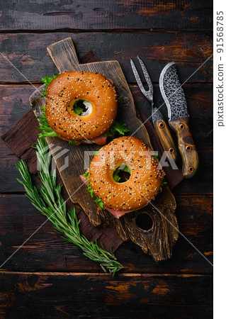 Cream cheese and smoked salmon bagel, on old dark wooden table background, top view flat lay Cream cheese and smoked salmon bagel, on old dark wooden table background, top view flat lay 91568785