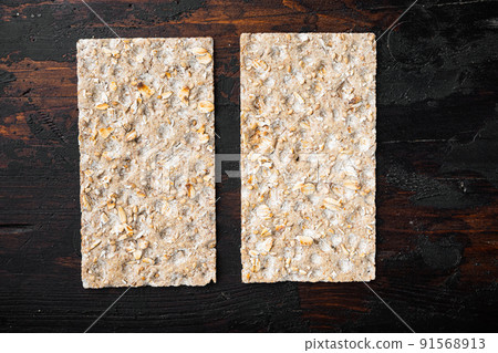 Wholegrain Rye Crispbread cracker, on old dark  wooden table background, top view flat lay, with copy space for text 91568913