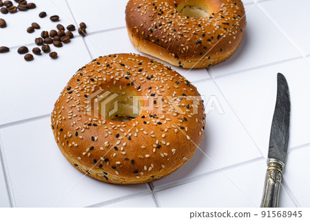 Bagel Freshly Baked  set, on white ceramic squared tile table background 91568945