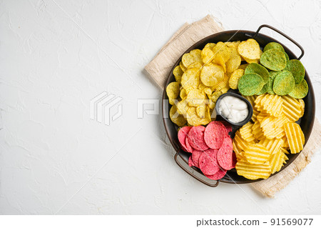 Crispy potato chips on white stone table background, top view flat lay, with copy space for text Crispy potato chips on white stone table background, top view flat lay, with copy space for text 91569077